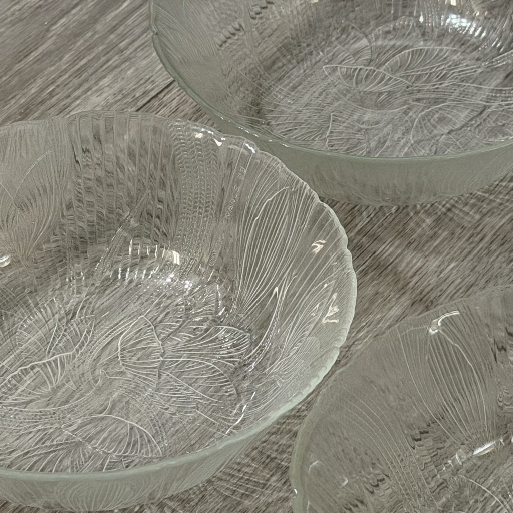 Set of glass bowls with leaf patterns on a wooden surface