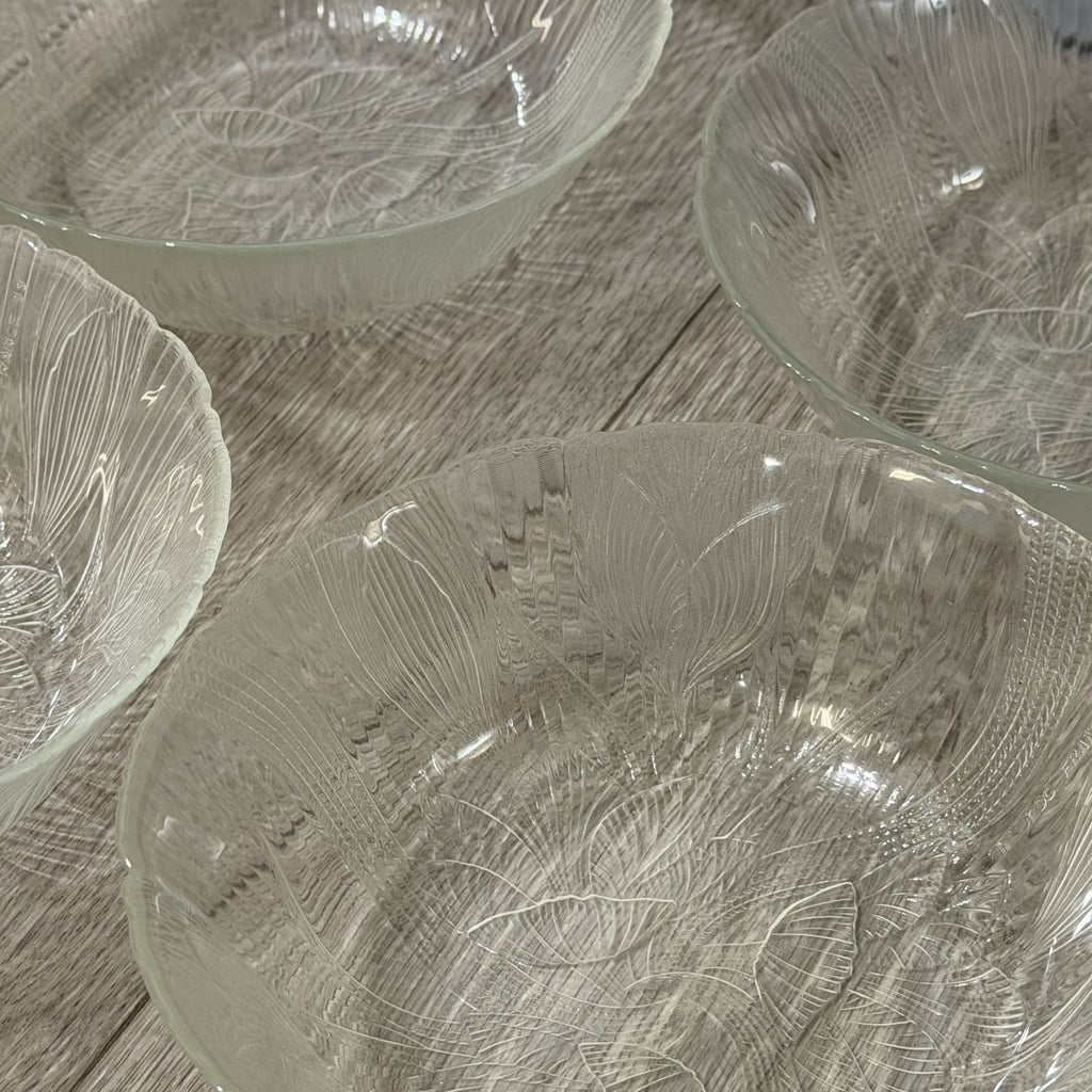Set of glass bowls with textured design on a wooden surface