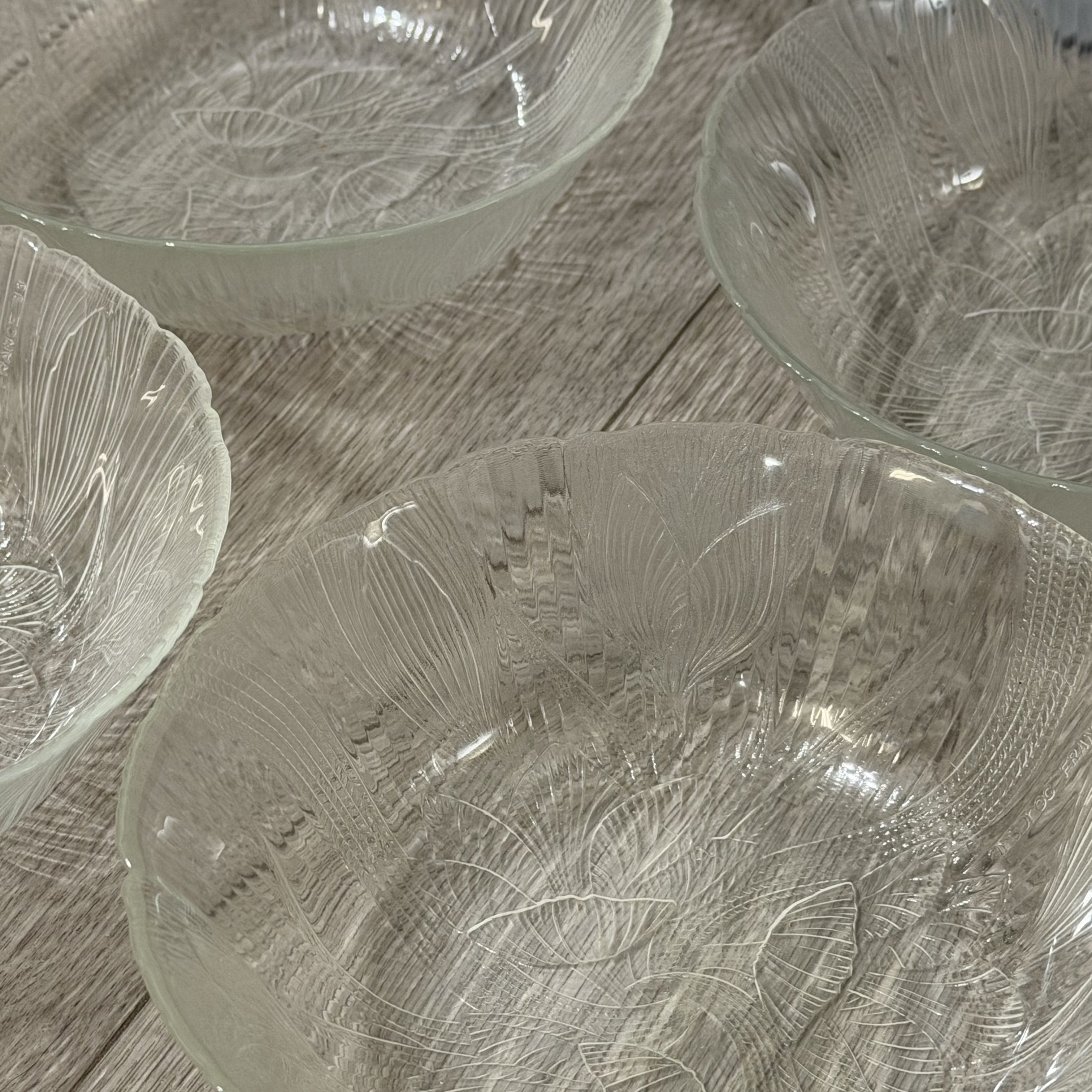 Set of glass bowls with textured design on a wooden surface