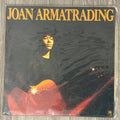 Vinyl record cover with a person holding a guitar and the text 'Joan Armatrading' on a reflective surface.